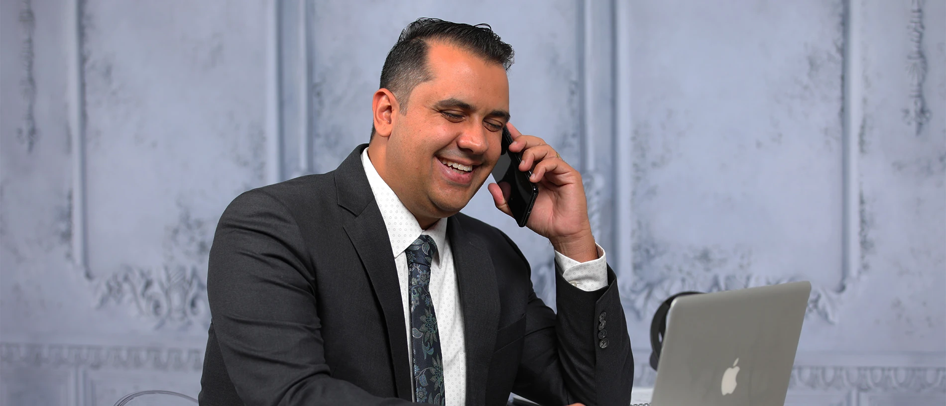 Felipe Mavromatis calling a client from his office, with a smile.